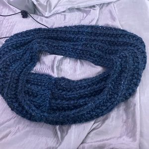 A hand knitted scarf that is navy blue and super soft.